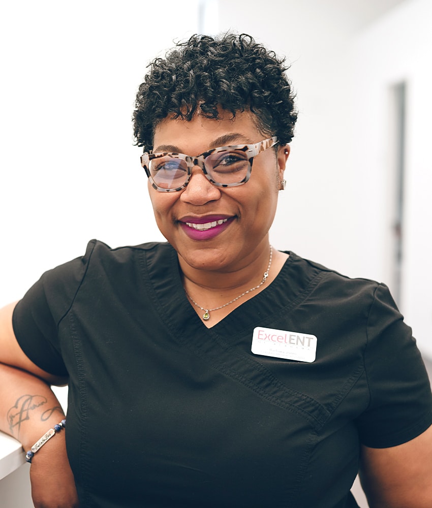 a person wearing glasses and smiling at the camera