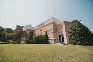 a large brick building with grass and trees