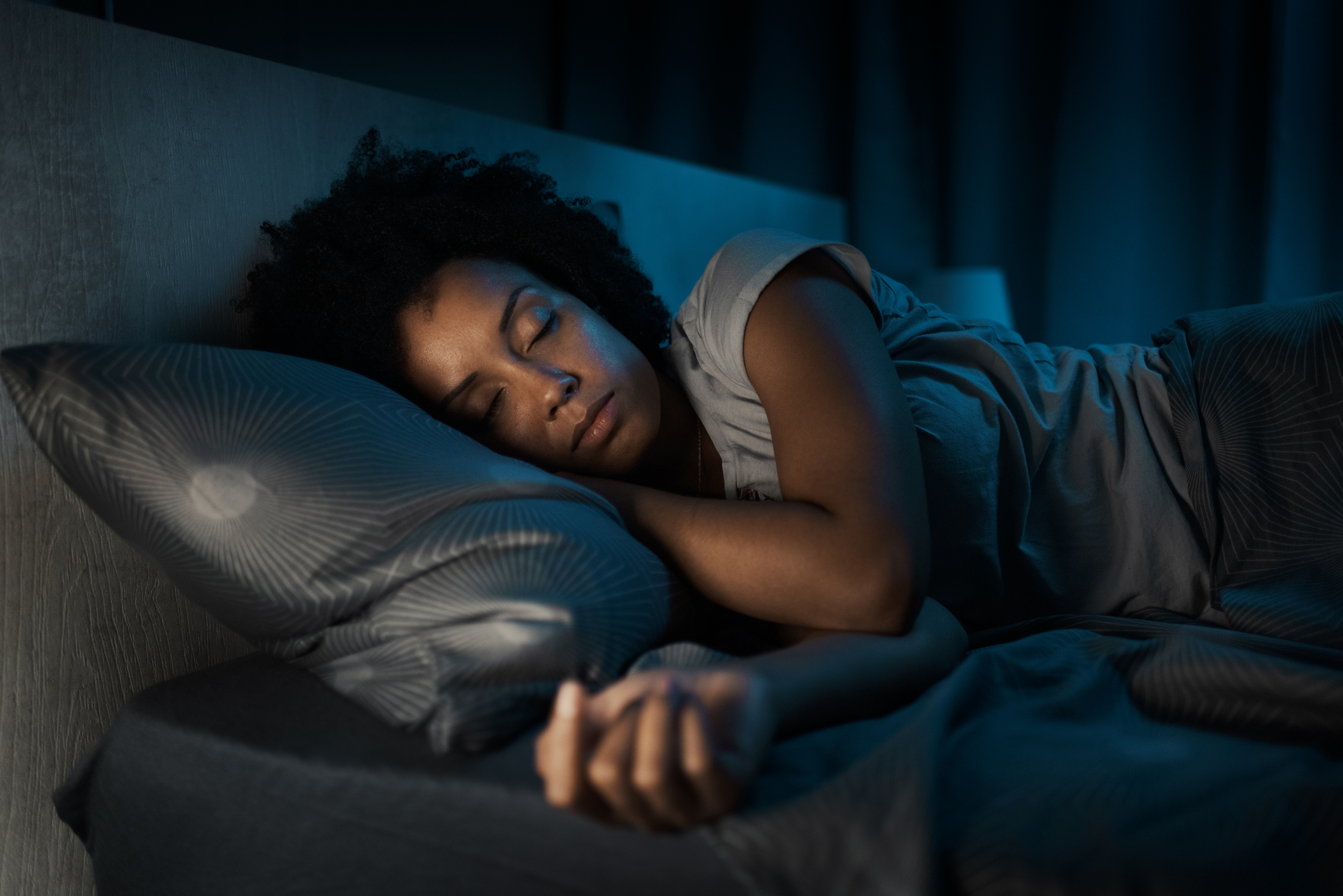A woman sleeping peacefully at night with a bedroom humidifier to support her nasal care after VivAer® recovery.